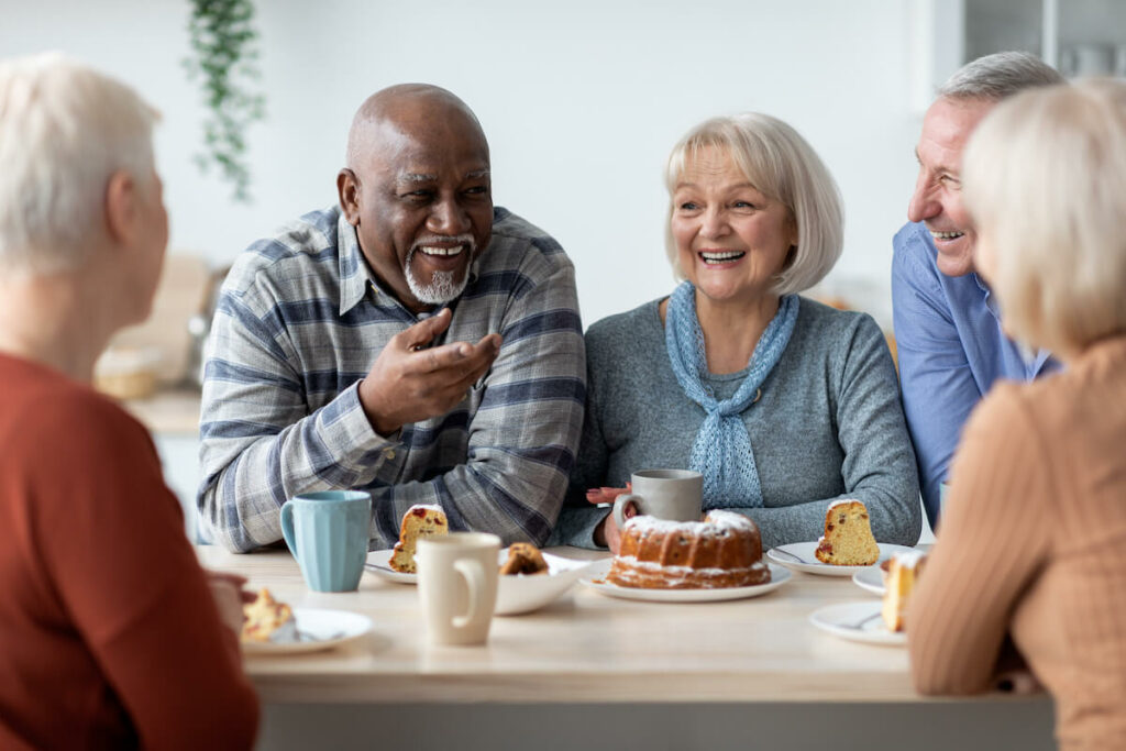 StoneCreek of Copperfield | Happy seniors talking and laughing at table together