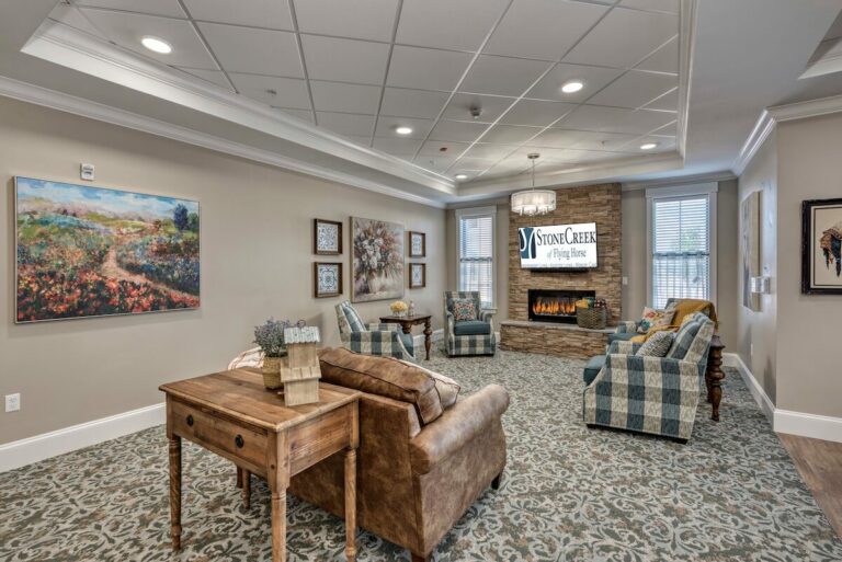 StoneCreek of Flying Horse | Memory care family room with fireplace