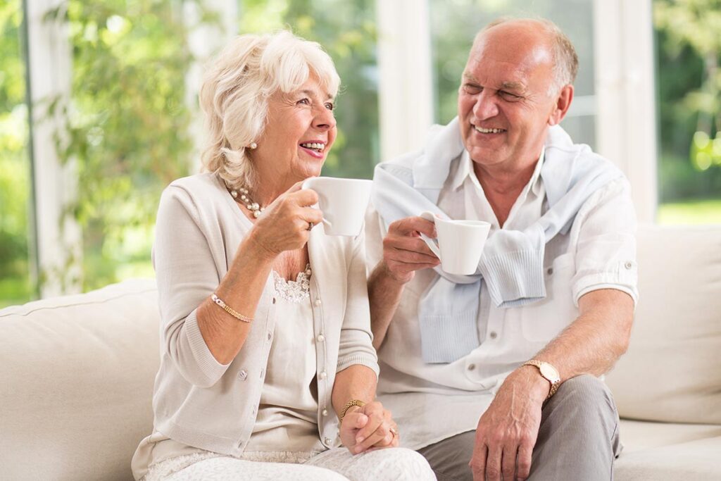 Valley View | Senior couple smiling and drinking coffee on the couch