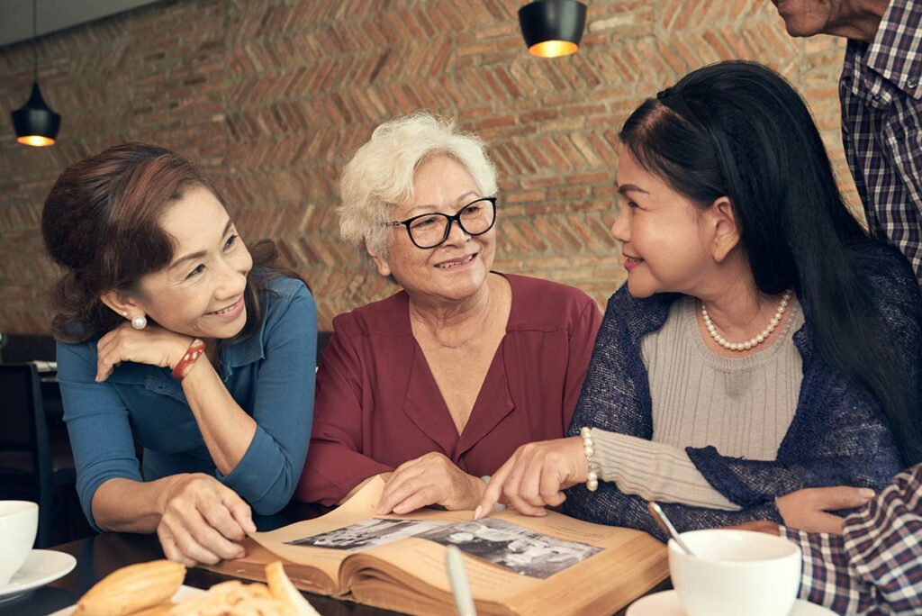 StoneCreek of Edmond | Senior woman and her family looking through a photo album