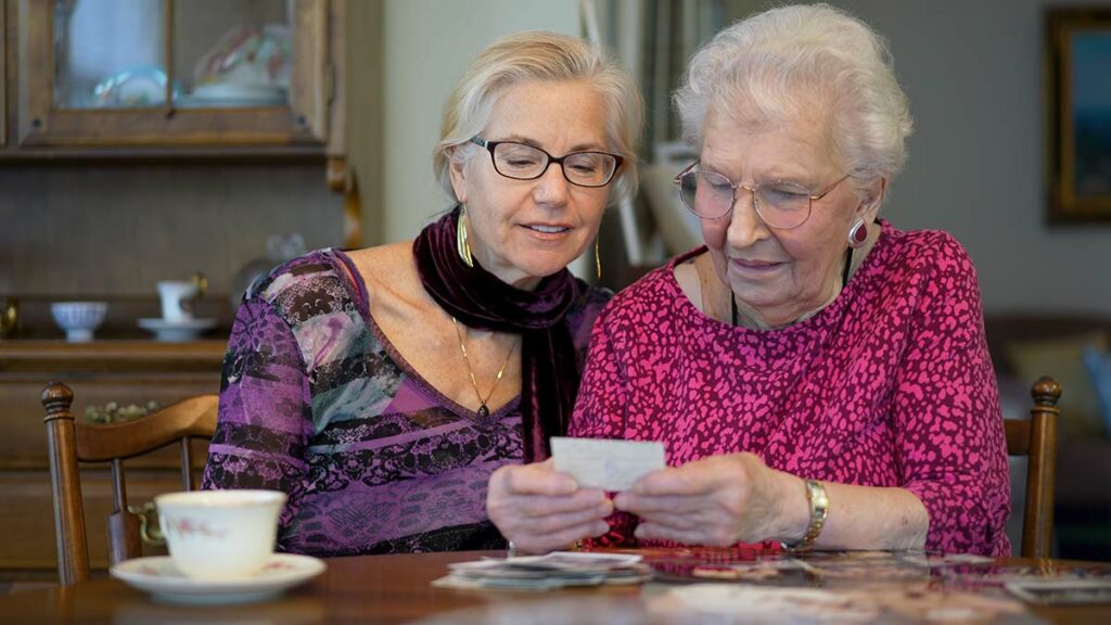 Ledgestone | Happy senior woman and her daughter looking through old photos