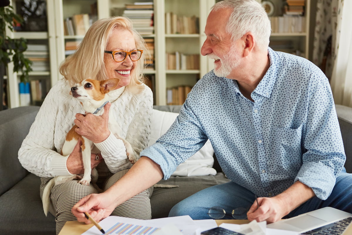 Civitas Senior Living | Senior couple and their dog analyzing their finances