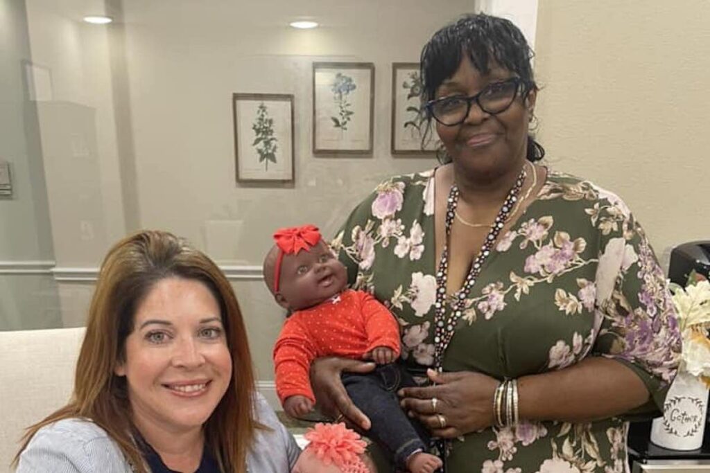 Arabella of Red Oak | Two caregivers holding baby dolls for The Grand Baby Project